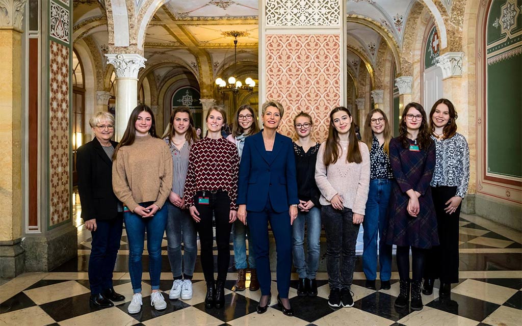 Foto di gruppo a Palazzo federale ovest: la consigliera federale Karin Keller-Sutter con le giovani donne lucernese invitate a Berna in occasione della Giornata internazionale delle donne