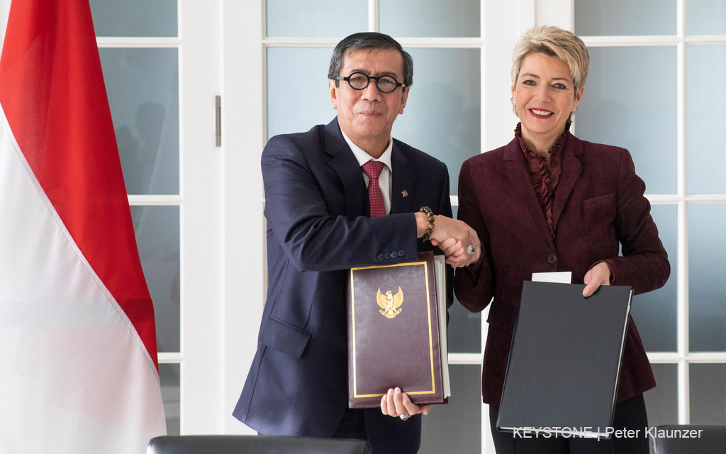 Federal Councillor Karin Keller-Sutter and the Indonesian Minister of Law and Human Rights Yasonna Laoly hold the signed treaties and shake hands
