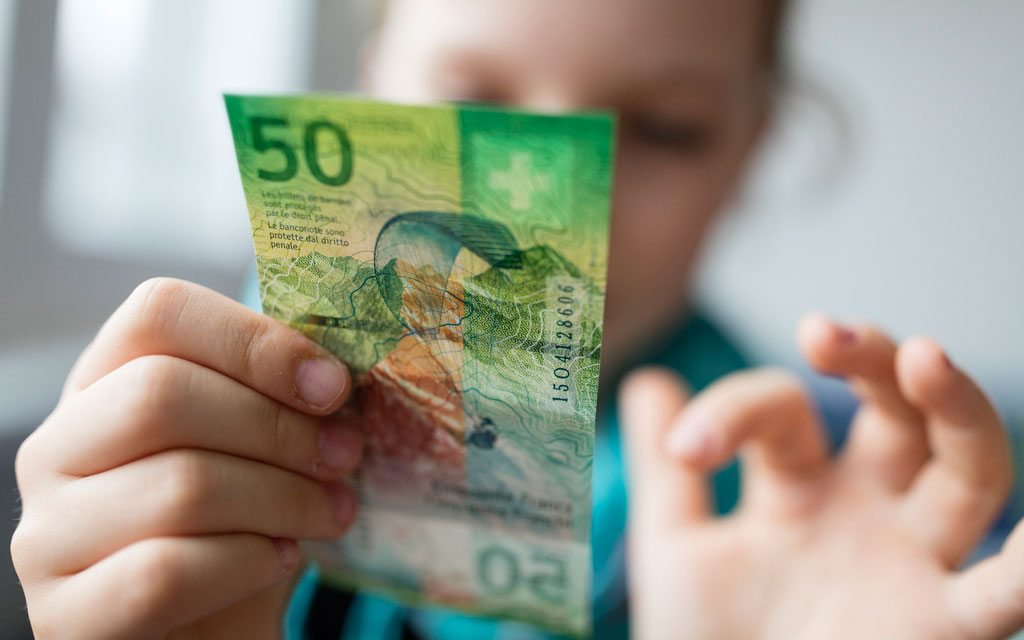 Ein Kind betrachtet eine 50-Franken-Note