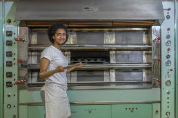 Una giovane donna si trova davanti a un forno.